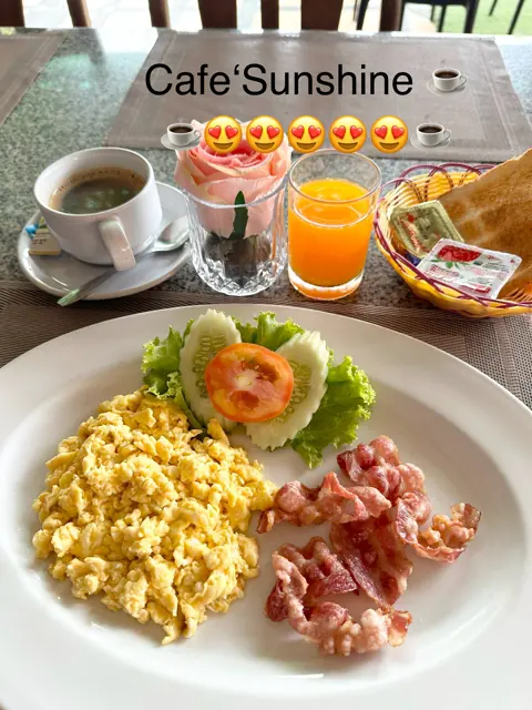 Eggs, bacon, juice and coffee on a breakfast table
