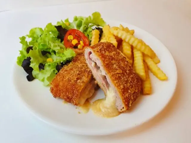 A breaded chicken dish with salad and fries