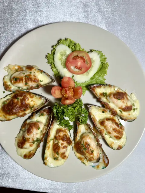Grilled seafood arranged around a cucumber garnish
