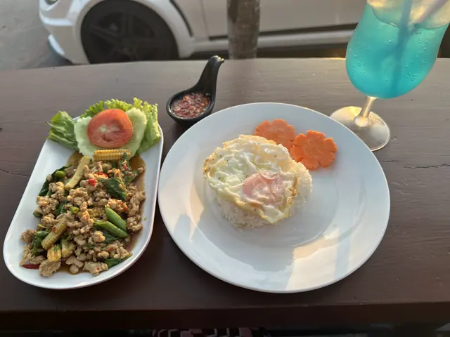 Two dishes and a drink on a table facing the road